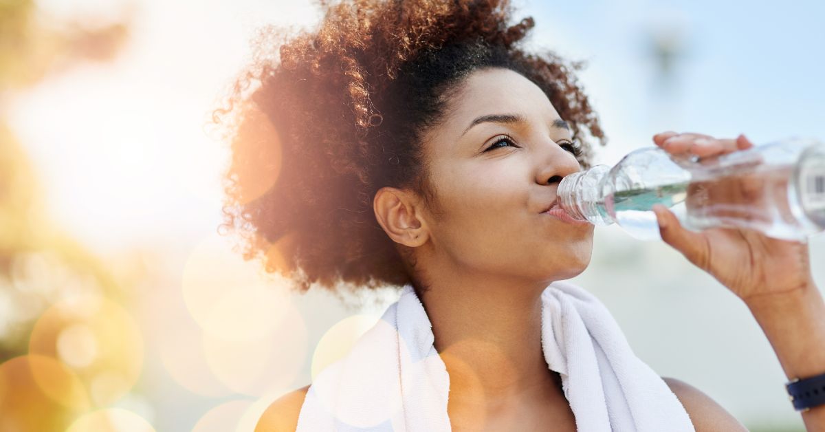 Photo of a woman drinking water promoting hydration tips for summer workouts by Sport & Spine Physical Therapy in Marshfield and Auburndale Wisconsin.