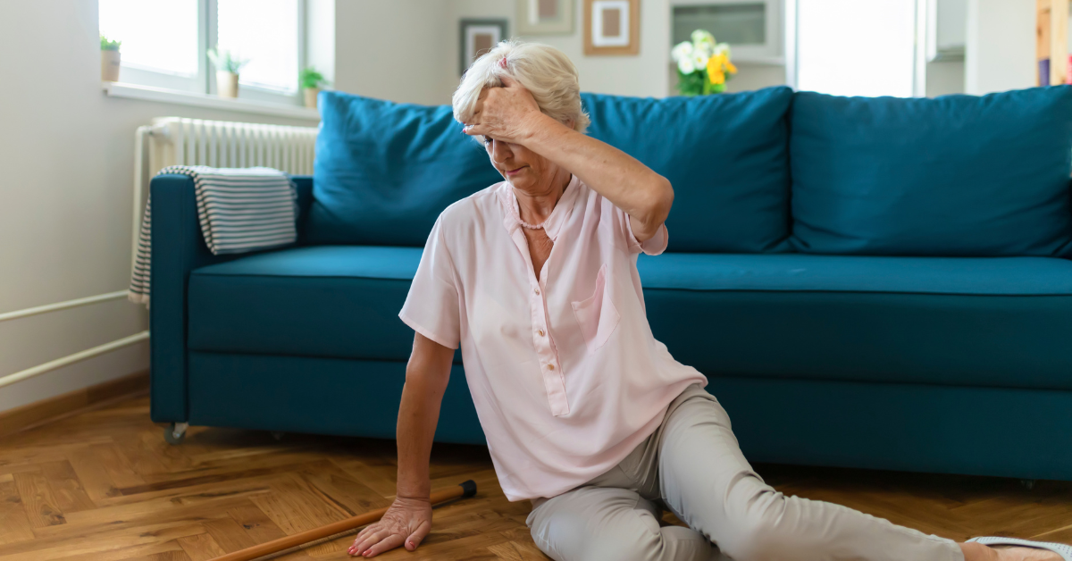 An older woman lying on the floor at home, emphasizing the importance of falls prevention.